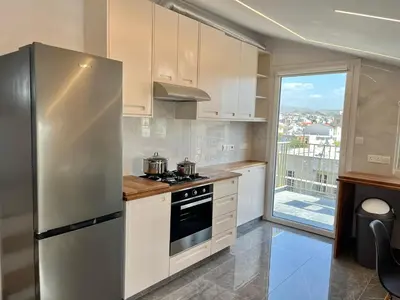 a kitchen with white cabinets and a stainless steel refrigerator at Trendy Loft Apartment in Limassol
