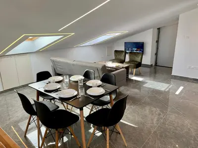 a living room with a table and chairs and a couch at Trendy Loft Apartment in Limassol