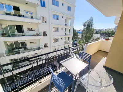 a balcony with chairs and tables on a building at City Vibrance Apartment in Larnaka