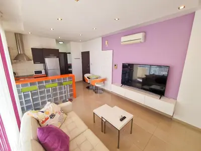 a living room with a couch and a fireplace at City Vibrance Apartment in Larnaka