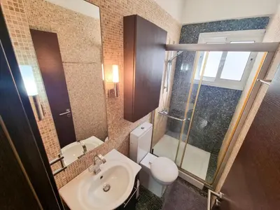 a bathroom with a toilet and a sink and a shower at City Vibrance Apartment in Larnaka