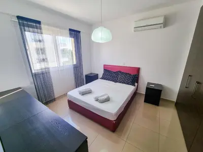 a bedroom with a bed with two pillows on it at City Vibrance Apartment in Larnaka
