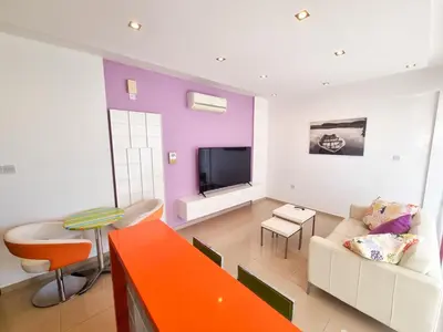 a living room with a couch and a tv at City Vibrance Apartment in Larnaka