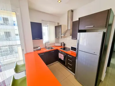 a kitchen with an orange counter top and a refrigerator at City Vibrance Apartment in Larnaka