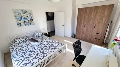 a bedroom with a bed and a table and a door at Center 2Br Apt w/ parking and 250m walk from beach in Larnaka