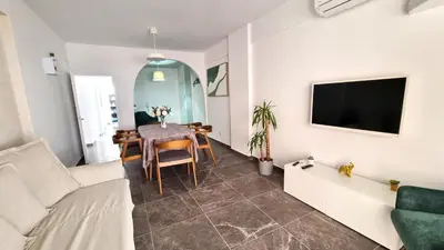 a living room with a table and a tv at Center 2Br Apt w/ parking and 250m walk from beach in Larnaka
