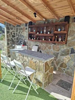 a patio with chairs and a stone wall at Marianna's House in Galata