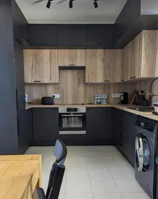 a kitchen with wooden cabinets and a washer and dryer at Luxury 2-Bedroom Apt. with Seaview in Protaras
