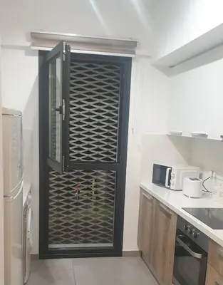 a kitchen with a glass door in a kitchen at Deluxe 1 Bed Apt Ayios Dometios in Ayios Dhometios