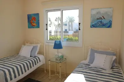 two beds in a room with a window at Villa Niki in Ayia Napa