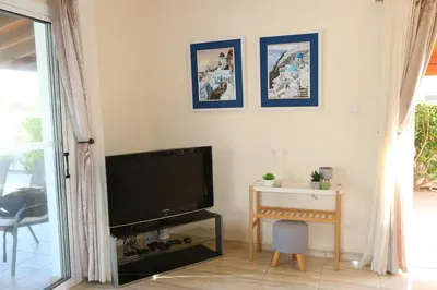 a living room with a flat screen tv and a table at Villa Niki in Ayia Napa