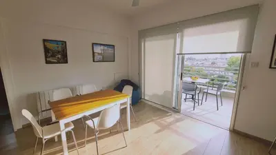 a dining room with a table and chairs and a balcony at STAY Mystique Apartment in Limassol