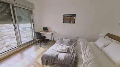 a bedroom with a bed and a desk with a laptop at STAY Mystique Apartment in Limassol