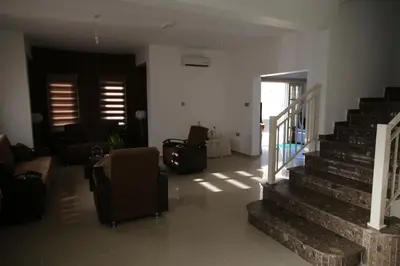 a living room with stairs and a couch and chairs at Villa Melyia in Kato Pyrgos