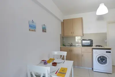 a kitchen with a table and a washing machine at Napa Hera 's Nest in Ayia Napa