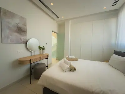 a white bedroom with a bed and a desk at City Napa Seaview Villas - Villa 7 in Ayia Napa