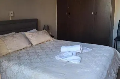 a bed with two towels sitting on top of it at 2br-7 Guests-Free Parking-Pool-AirCon in Paralimni