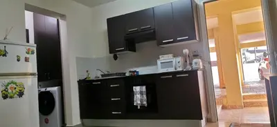 a kitchen with black cabinets and a white microwave at 2br-7 Guests-Free Parking-Pool-AirCon in Paralimni