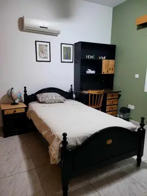 a bedroom with a bed and a dresser and a table at Beautiful bedroom in Limassol