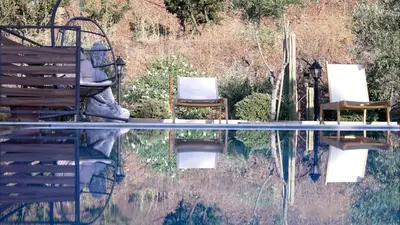two chairs sitting next to a pool of water at Mountain Retreat in Troodos