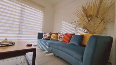 a living room with a blue couch with colorful pillows at STAY Naturaleza Penthouse in Limassol