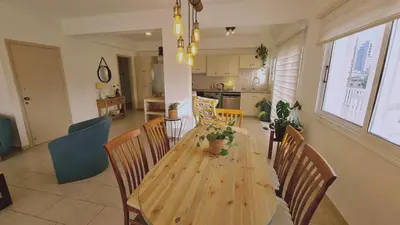 a dining room and kitchen with a wooden table and chairs at STAY Naturaleza Penthouse in Limassol