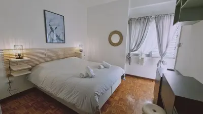 a bedroom with a bed and a desk and window at STAY Antique Apartment in Larnaka