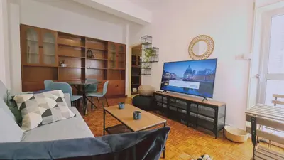 a living room with a couch and a flat screen tv at STAY Antique Apartment in Larnaka