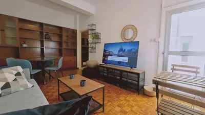 a living room with a couch and a flat screen tv at STAY Antique Apartment in Larnaka