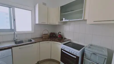 a white kitchen with a sink and a stove at STAY Antique Apartment in Larnaka