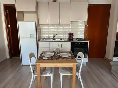 a small kitchen with a table and a refrigerator at Ellados 20 in Limassol