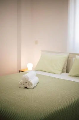 a bed with towels on top of it at Sunrise Beach Apartments in Larnaka