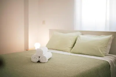 a bed with two rolls of towels on it at Sunrise Beach Apartments in Larnaka