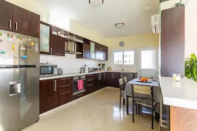 a large kitchen with a table and a refrigerator at Central Bliss / your perfect home away from home in Limassol