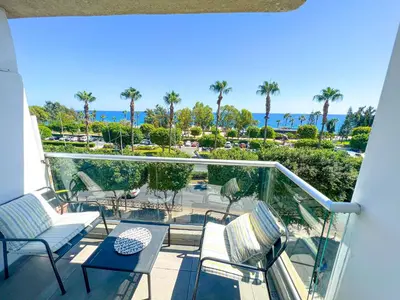 a balcony with a view of the ocean and palm trees at Panoramic Sea View Apt - 2bed in Limassol