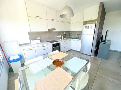 a kitchen with a glass table with chairs and a refrigerator at Panoramic Sea View Apt - 2bed in Limassol