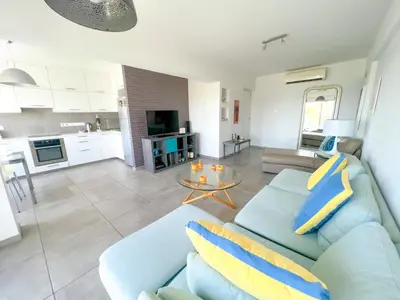 a living room with a blue couch and a table at Panoramic Sea View Apt - 2bed in Limassol
