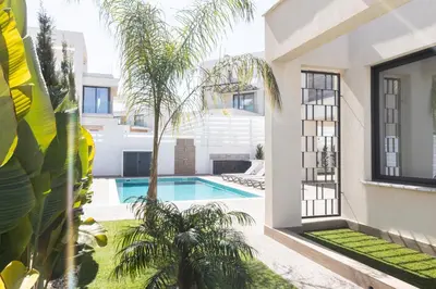an external view of a house with a swimming pool and palm trees at Luxury Panorama Villa Protaras in Protaras