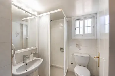 a white bathroom with a toilet and a sink at Platres Forest Panorama Cottage in Platres