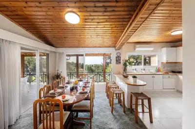 a kitchen and dining room with a long table and chairs at Platres Forest Panorama Cottage in Platres