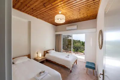 two beds in a room with a window at Platres Forest Panorama Cottage in Platres