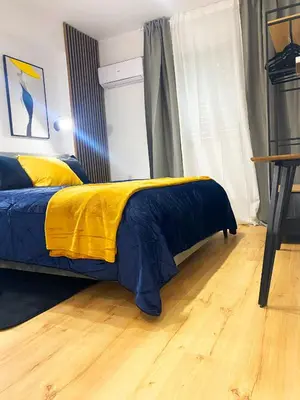 a bedroom with a bed with a yellow and blue blanket at Luxury City Retreat- 2-Bedroom, 2-Bath Apartment in Nicosia