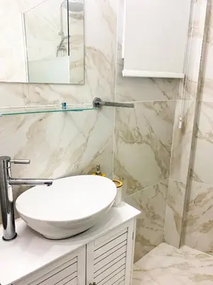 a bathroom with a white sink and marble walls at Luxury City Retreat- 2-Bedroom, 2-Bath Apartment in Nicosia