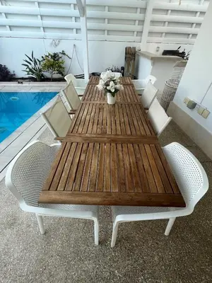 a wooden table and chairs on a patio with a pool at Riverland Turtle Beach Villa-1min walk to beach in Protaras