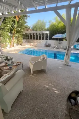 a patio with a pool and chairs and a table at Riverland Turtle Beach Villa-1min walk to beach in Protaras