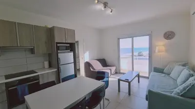 a kitchen and living room with a couch and a table at STAY Beach Wave Apartment in Larnaka