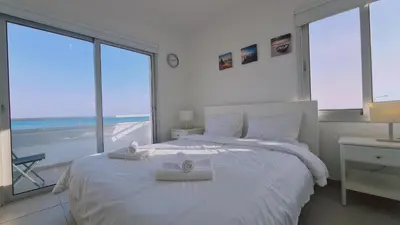 a bedroom with a white bed with two towels on it at STAY Beach Wave Apartment in Larnaka