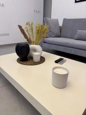 a white coffee table with a candle and a couch at Panorama Residence in Nicosia