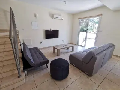 a living room with a couch and a tv at Mythical Sands BG03 townhouse in Paralimni