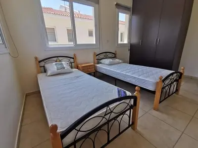two beds in a room with a window at Mythical Sands BG03 townhouse in Paralimni